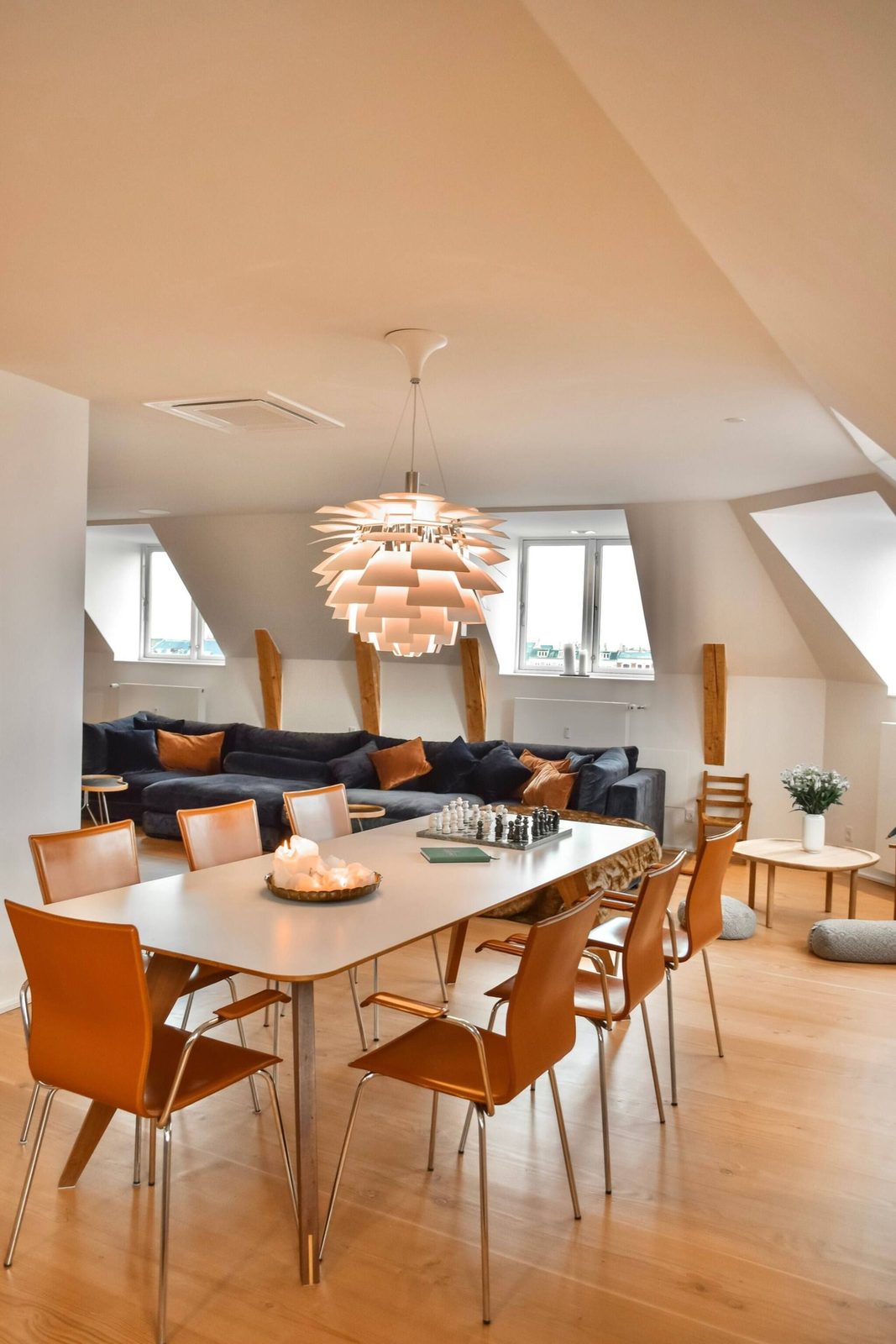 Dining table for eight beneath a sculptural pendant